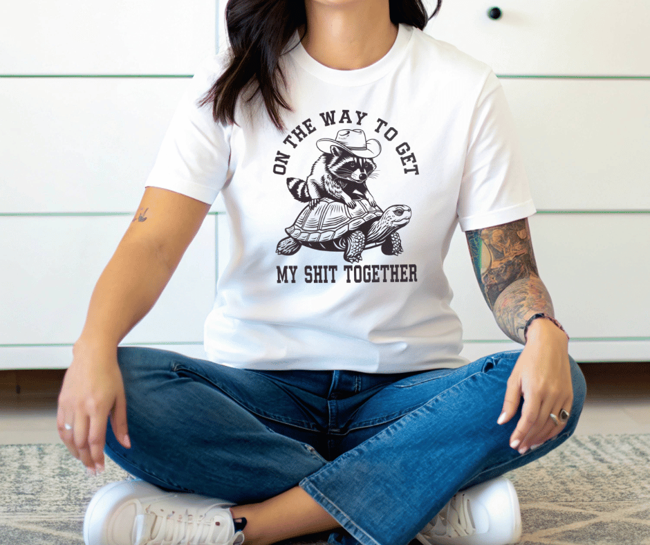 Graphic T-Shirt With Racoon Sitting On A Turtle And The Text On The Way To Get My Shit Together