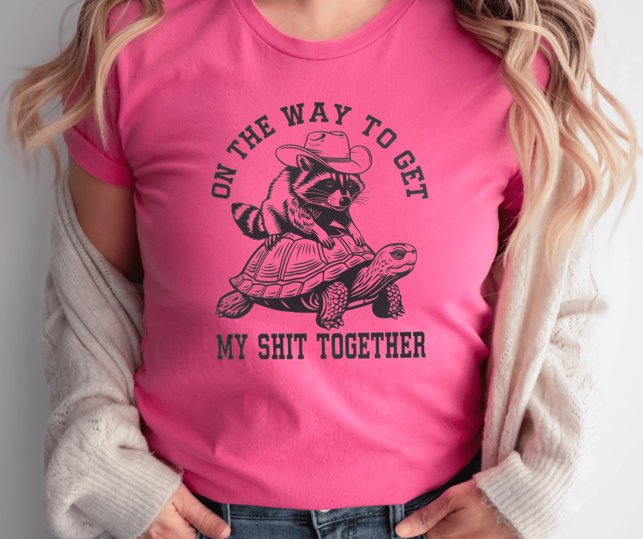 Graphic T-Shirt With Racoon Sitting On A Turtle And The Text On The Way To Get My Shit Together