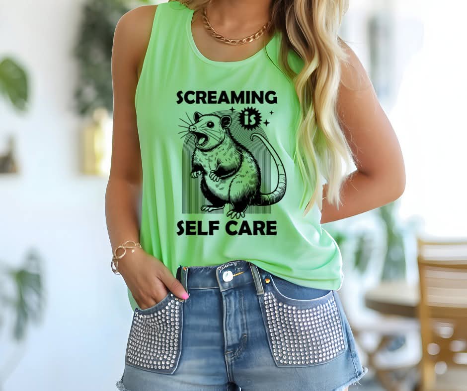 Person wearing a tank top with possum graphic and text that says Screaming is Self Care