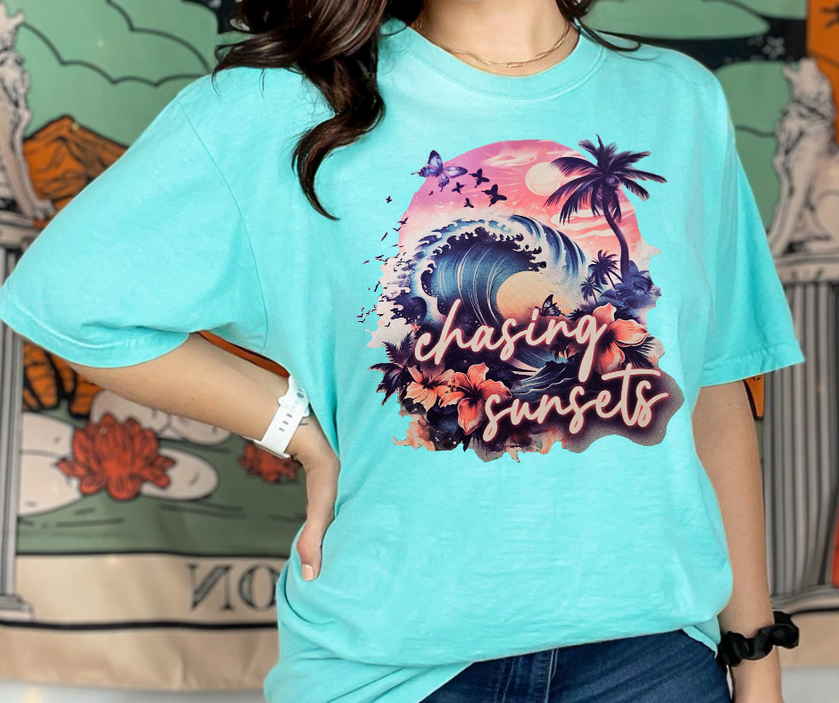 graphic t-shirt that says chasing sunsets with a wave and palm tree