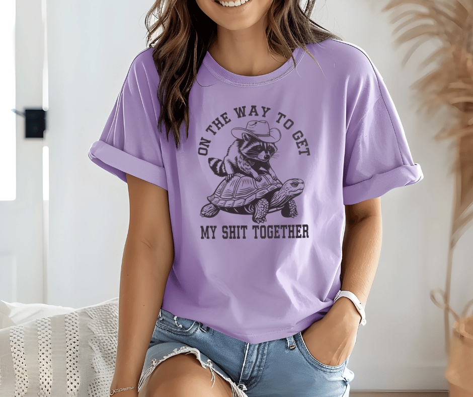 Graphic T-Shirt With Racoon Sitting On A Turtle And The Text On The Way To Get My Shit Together