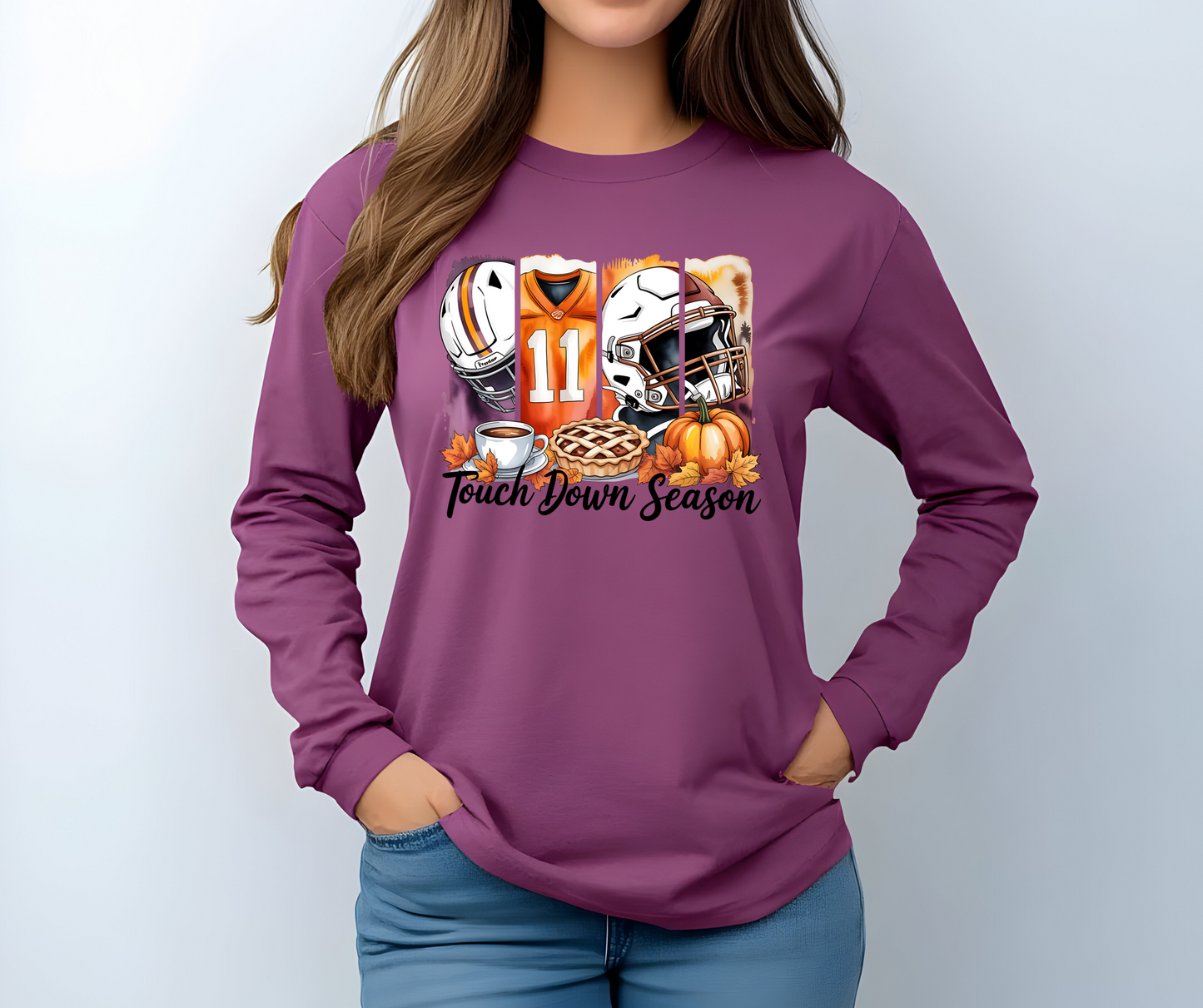 Berry colored long-sleeve  graphic t-shirt with football-themed design featuring a helmet, jersey, and pie with the words Touch Down Season 