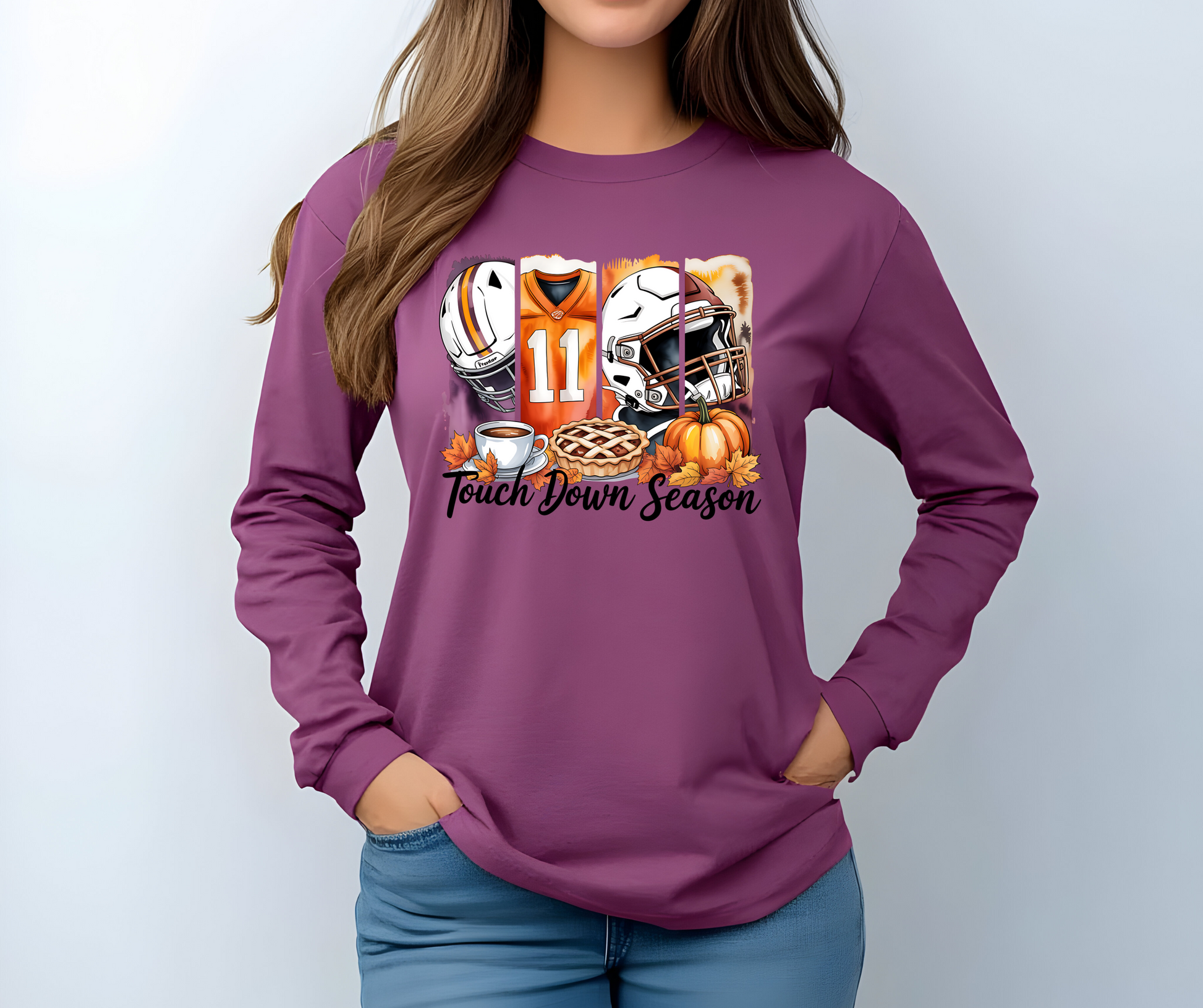 Berry colored long-sleeve  graphic t-shirt with football-themed design featuring a helmet, jersey, and pie with the words Touch Down Season 