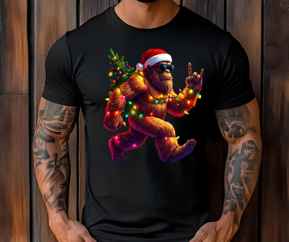 Graphic Christmas T-Shirt With Big Foot Wrapped in Lights Wearing Santa Hat