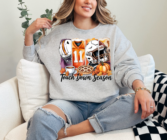 Person wearing a sweatshirt with football-themed graphics and 'Touchdown Season' text