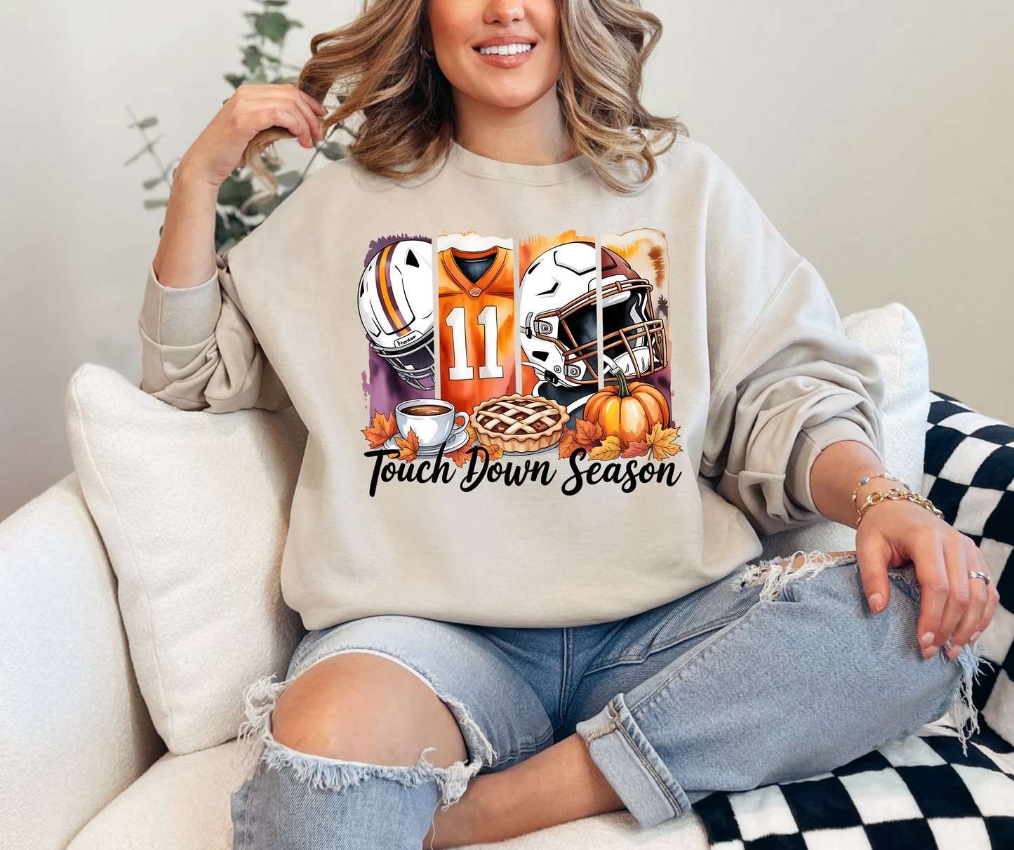 Person wearing a sweatshirt with football-themed graphics and 'Touchdown Season' text