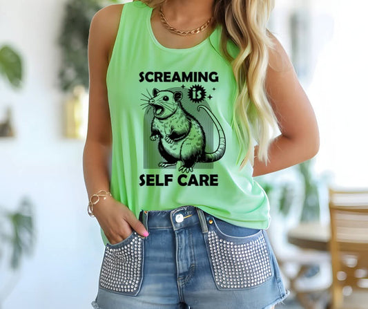Person wearing a tank top with possum graphic and text that says Screaming is Self Care